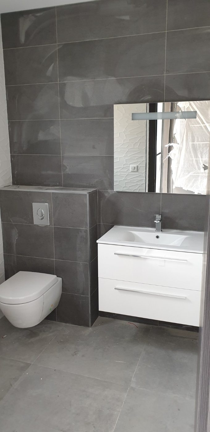 Salle d’eau grise avec douche et meuble vasque